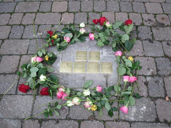 Bild vergrößern: Stolpersteine mit Blumenkranz