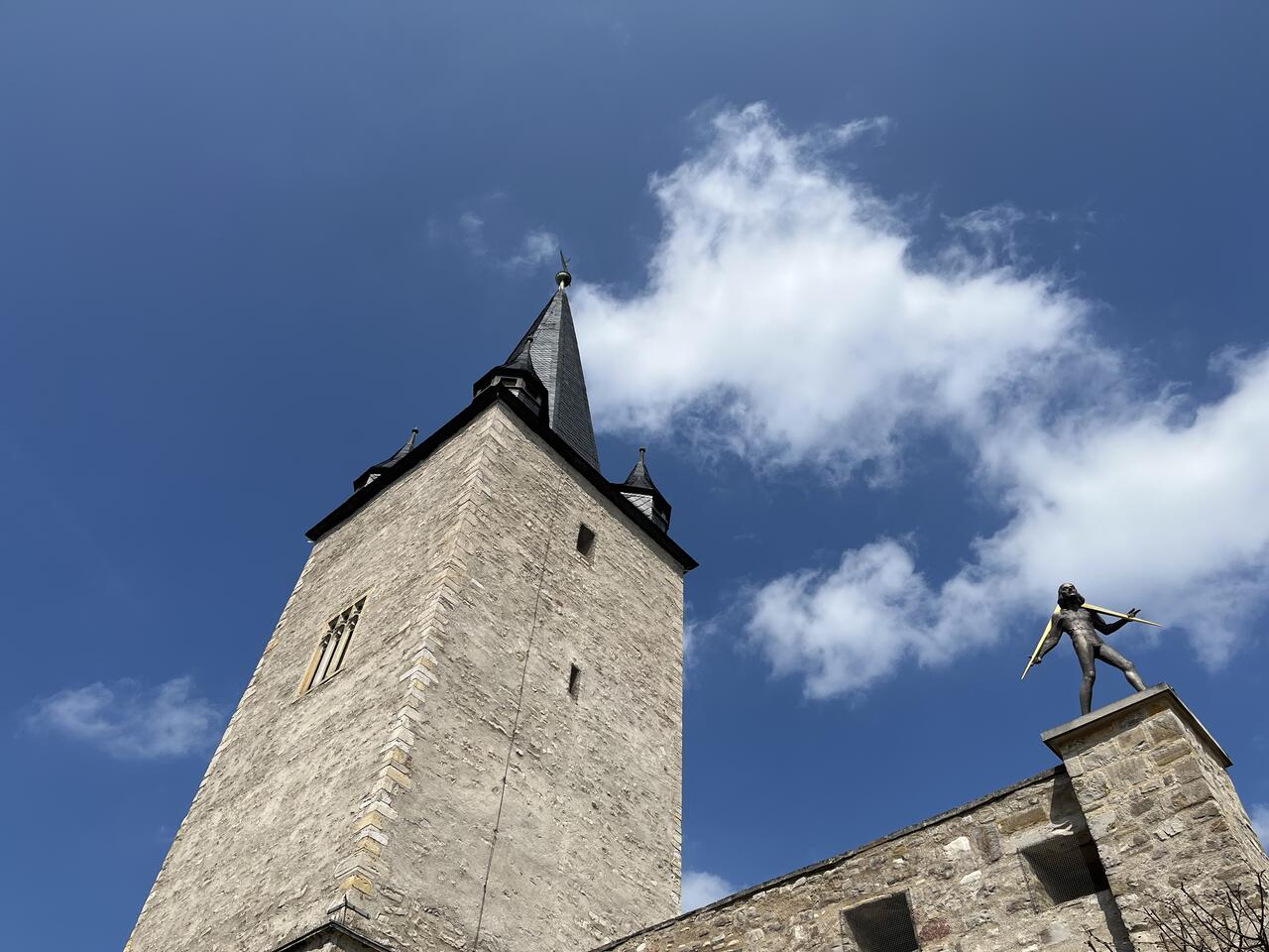 Bild vergrößern: Adam Olearius Denkmal vor der Kulisse des Johannistorturms